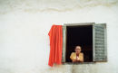 Monk Leaning Out Of Window, Phnom Penh, Cambodia