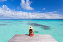 Woman sitting on pier, Fakarava, French Polynesia