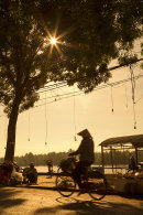 Woman cycling at dawn, Ben Tre