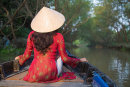 Woman wearing ao dai dress on canal, Can Tho, Vietnam