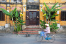 Woman cycling past restaurant, Hoi An