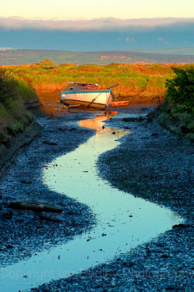 Lone yacht at low tide on Penngton Marsh, Lymington, Hampshire, England
