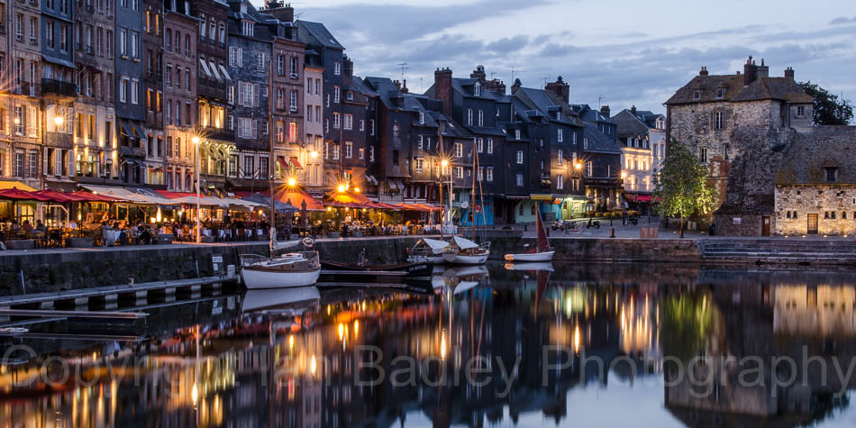 Sailing boats moored at the old port of Honfleur, Normandy, France, at dusk