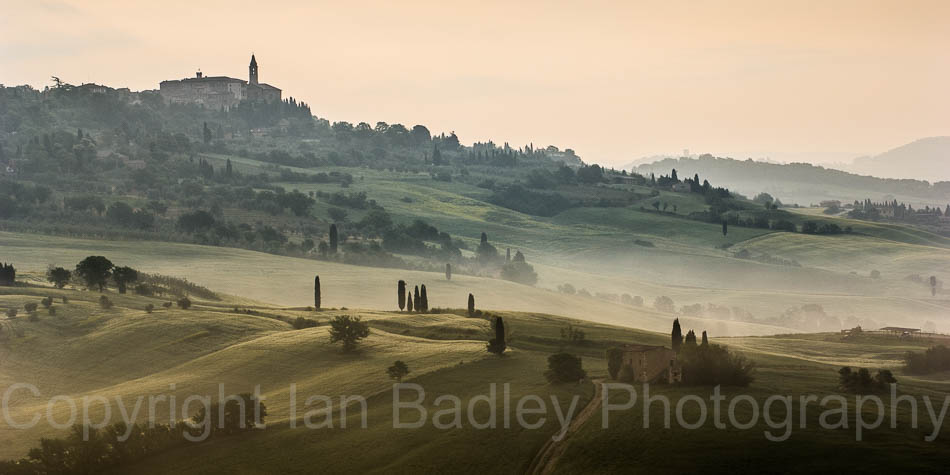 Cypress trees over rolling hills below Pienza, Tuscany, Italy