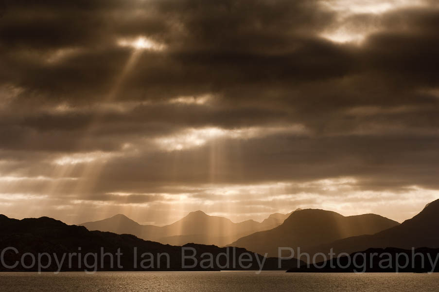Sun light though the storm clouds over highland mountains, Scotland