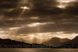 Sun light though the storm clouds over highland mountains, Scotland