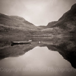 Moored boat on a still Loch Marie, Scotland