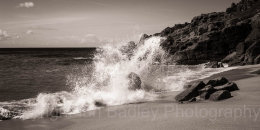 Waves crashing on rocks and a sandy beach, Cornwall, England