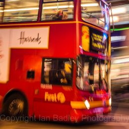 Red London bus moving at night