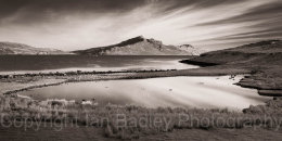 Sky streaks and view over pond and sea towards the Totternish Ridge, Isle of Skye, Scotland
