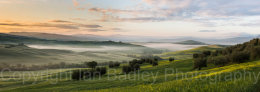 Green grass and sunrise over the UNESCO Val d'Orcia, Italy