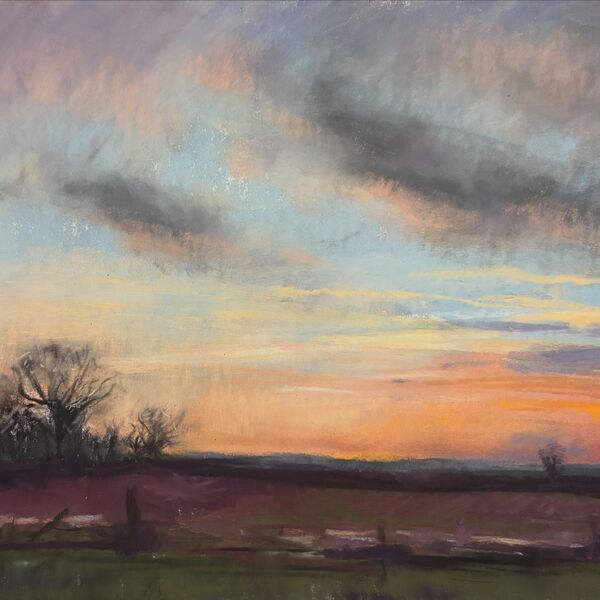 View over the fields of Frostenden, Suffolk with a golden sunset and fluffy clouds