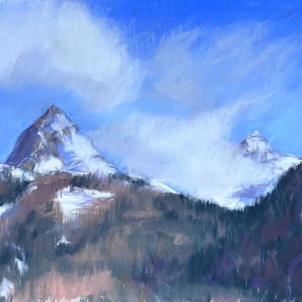 View from the balcony of the hotel looking up the mountains with pine forests and snow topped peaks