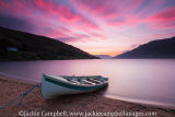 Boat on lake shore at sunrise