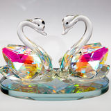 glass swans bathing in reflected light