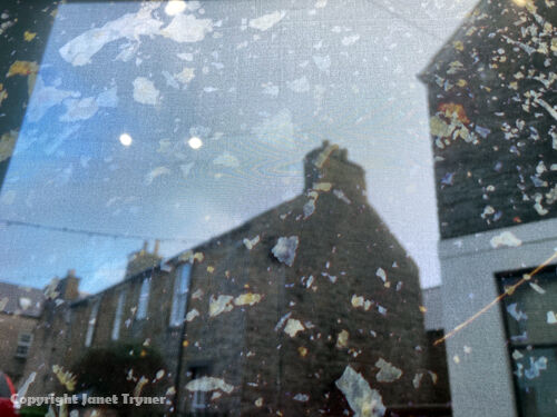 Image of calthemite fragments printed on voile through which a view of Stromness Orkney can be seen