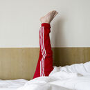 Nach oben gestreckte Beine eines Menschen im Bett