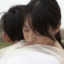 2 menschen umarmen sich. eine Person hat die Augen geschlossen