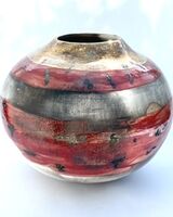 Red smoke-fired pot with gold lustre.