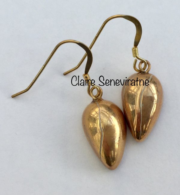 Small gold teardrop earrings.