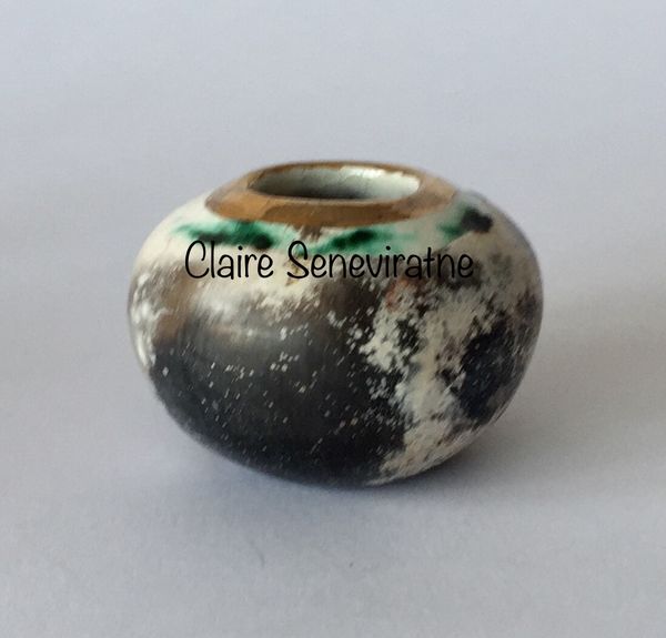 Small smoked fired vessel with gold.