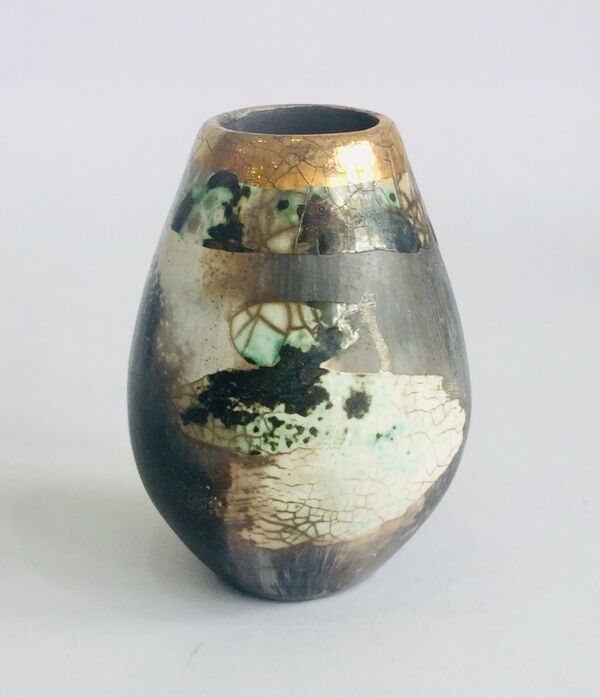 Small upright smoke-fired ceramic pot.