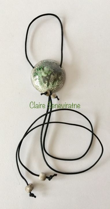 Round raku pendant with greens,greys and white.