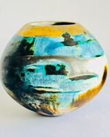 Blue smoke-fired ceramic pot with glaze and gold lustre.