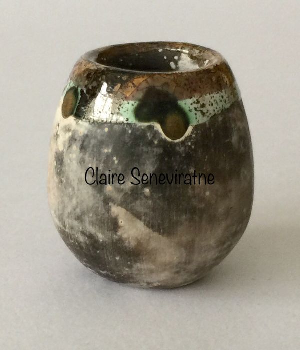 Tiny upright smoke fired pot.