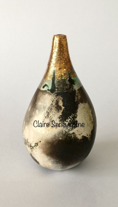 Small smoke fired pot with a gold neck.
