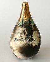 Small smoke fired pot with a gold neck.