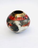 Red smoke-fired pot with gold lustre.