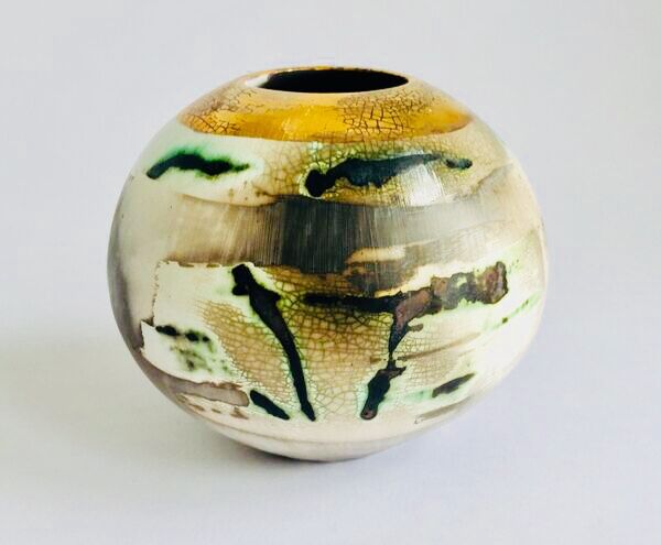 Burnished smoke-fired ceramic pot with gold lustre.