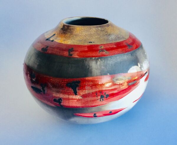 Red smoke-fired pot with gold lustre.