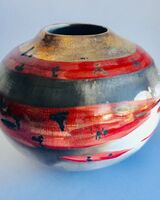 Red smoke-fired pot with gold lustre.