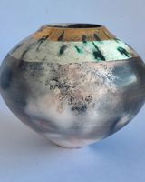 Round smoke-fired pot with glaze and gold lustre.