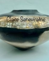 Round smoke-fired porcelain vessel with gold lustre.