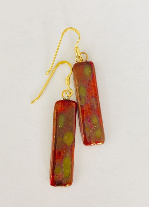 Red rectangular ceramic earrings with matt gold patterns.
