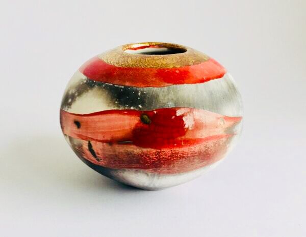 Red smoke-fired pot with gold lustre.