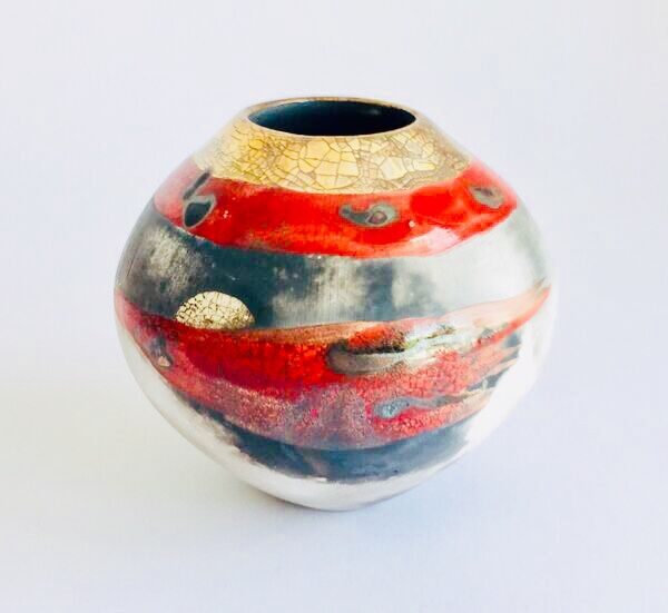 Red smoke-fired pot with gold lustre.