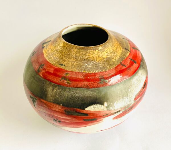 Red smoke-fired pot with gold lustre.