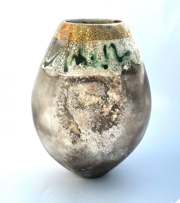 Smoke-fired pot with gold lustre and copper carbonate markings.