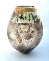 Smoke-fired pot with gold lustre and copper carbonate markings.