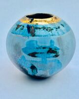 Small round blue smoke-fired ceramic pot with gold lustre.