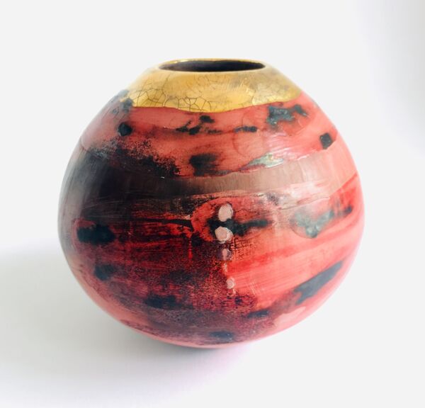 Red smoke-fired pot with gold lustre.