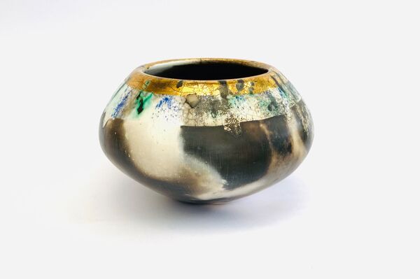 Burnished smoke-fired ceramic pot with gold lustre.