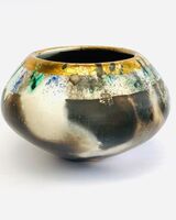 Burnished smoke-fired ceramic pot with gold lustre.