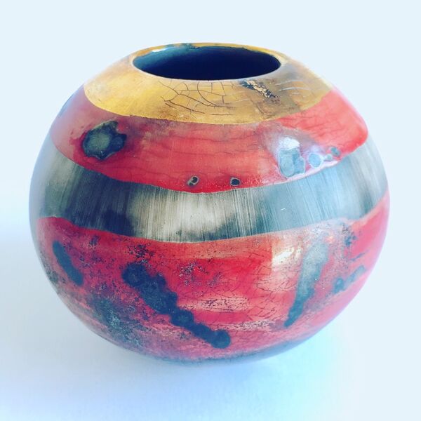 Small red smoke-fired porcelain vessel.
