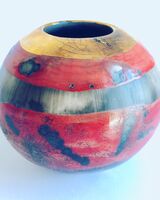 Small red smoke-fired porcelain vessel.