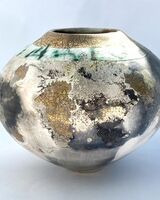 Round smoke-fired pot with glaze and gold lustre.